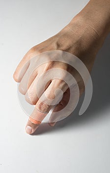 Female finger with adhesive bandage