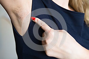 Female finger shows unshaven armpit.