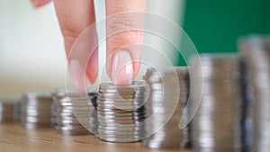 Female fingers going up on bar chart made of coins photo