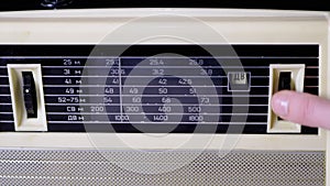 A Female Fingers Tuning the Frequency on an Old Vintage Analog Receiver