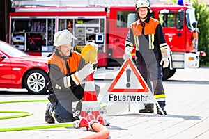 Female fire fighters setting up attention sign photo