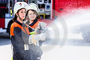 Female fire fighters spouting water to extinguish