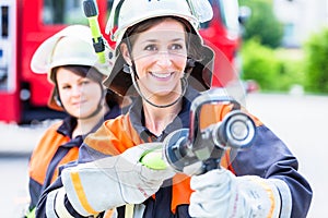 Female fire fighters spouting water to extinguish