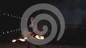 Female fireshow artist spinning fire hoop outdoor