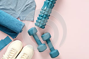 Female fitness flat lay, sneakers, dumbbells, on pastel pink background.Feminine sports, workouts, healthy lifestyle