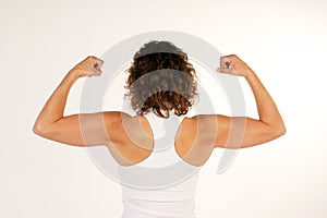 Female fitness instructor flexing arm muscles