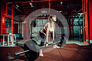 Female fitness performing doing deadlift exercise with weight bar