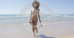 Female with flippers walking on beach