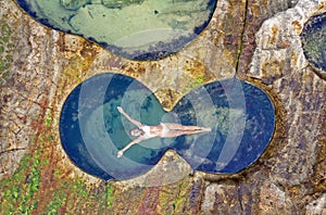 Female floating in idyllic ocean rock pool just bliss