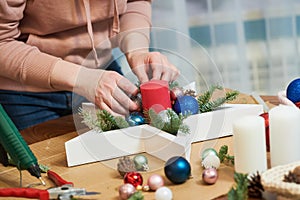 Female florist decorator making Christmas wreath