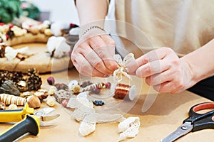 Female florist decorator making Christmas wreath