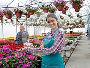 Female florist in greenhouse against flowers