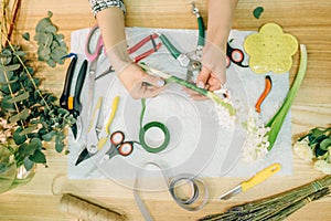 Florist hands doing flower composition, top view photo