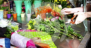 Female florist trimming flower stem in flower shop