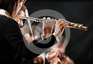Female flutist with orchestra on stage