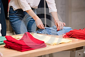 Female fold blue clothes at clothing store