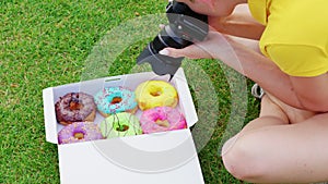 Female food photographer shooting donuts. Close up