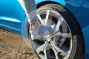 Female foot on car wheel