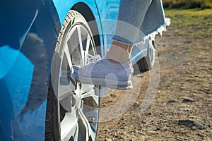 Female foot on car wheel