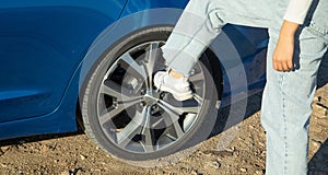 Female foot on car wheel