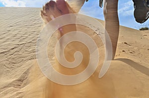 Female foot digs sand
