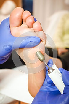 Female foot in the process of pedicure procedure in a beauty salon close-up
