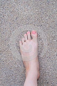 Female Foot Top View. Pink Nail Polish Manicure. Selfie of Woman Bare Feet On Road Background