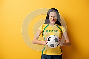 Female football fan holding ball on