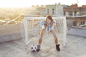 Female football fan standing as goalkeeper