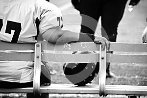 Female Football Player Sitting On Sideline