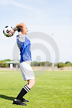 Female football player about to throw a football