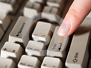 Female forefinger pushes ENTER button. Close-up