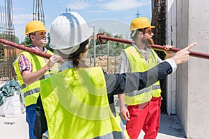Female foreman coordinating and guiding workers on the construction site photo