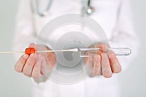 Female forensic technician collecting biological specimen in DNA