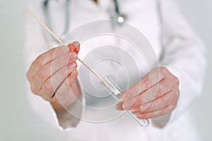 Female forensic technician collecting biological specimen in DNA