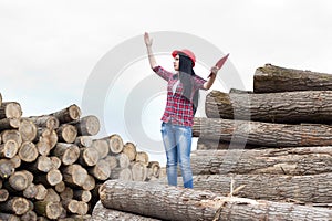 Female forestry engineer beside logs