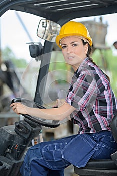 Female fork lift truck driver in factory