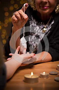 Female fortune teller using pendulum