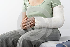 Female With Fractured Hand Sitting On Bed photo