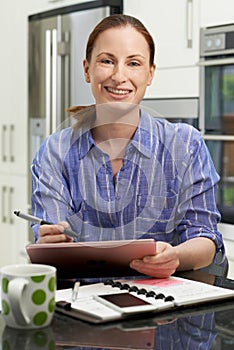 Female Freelance Worker Using Digital Graphics Tablet At Home