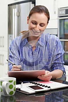 Female Freelance Worker Using Digital Graphics Tablet At Home