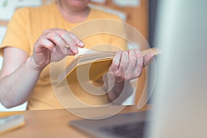 Female freelancer reading book in home office