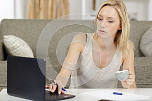 female freelancer using laptop and drinking coffee