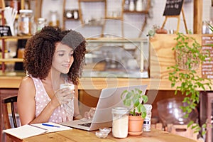 Female freelancer working in a coffee shop on her laptop