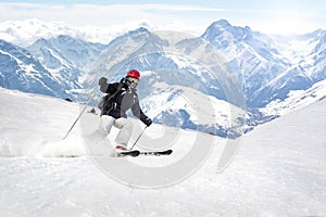 Female freerider skier rolls and rides with powder snow spraying