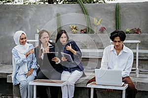 female friend avoids male friend using laptop in coworking space outdoors