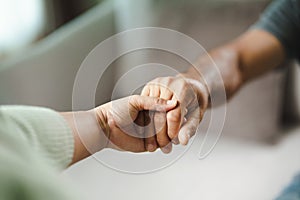 Female friend or family holding hands during cheer up to mental depress man, Psychologist provides mental aid to patient. PTSD