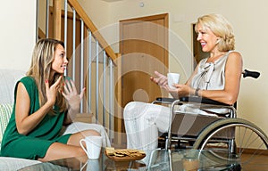 Female friend visiting disabled woman