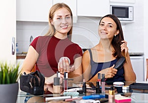 Female friends applying cosmetics