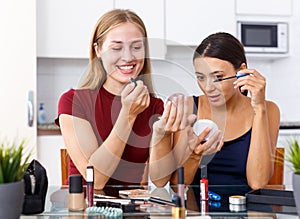 Female friends applying cosmetics